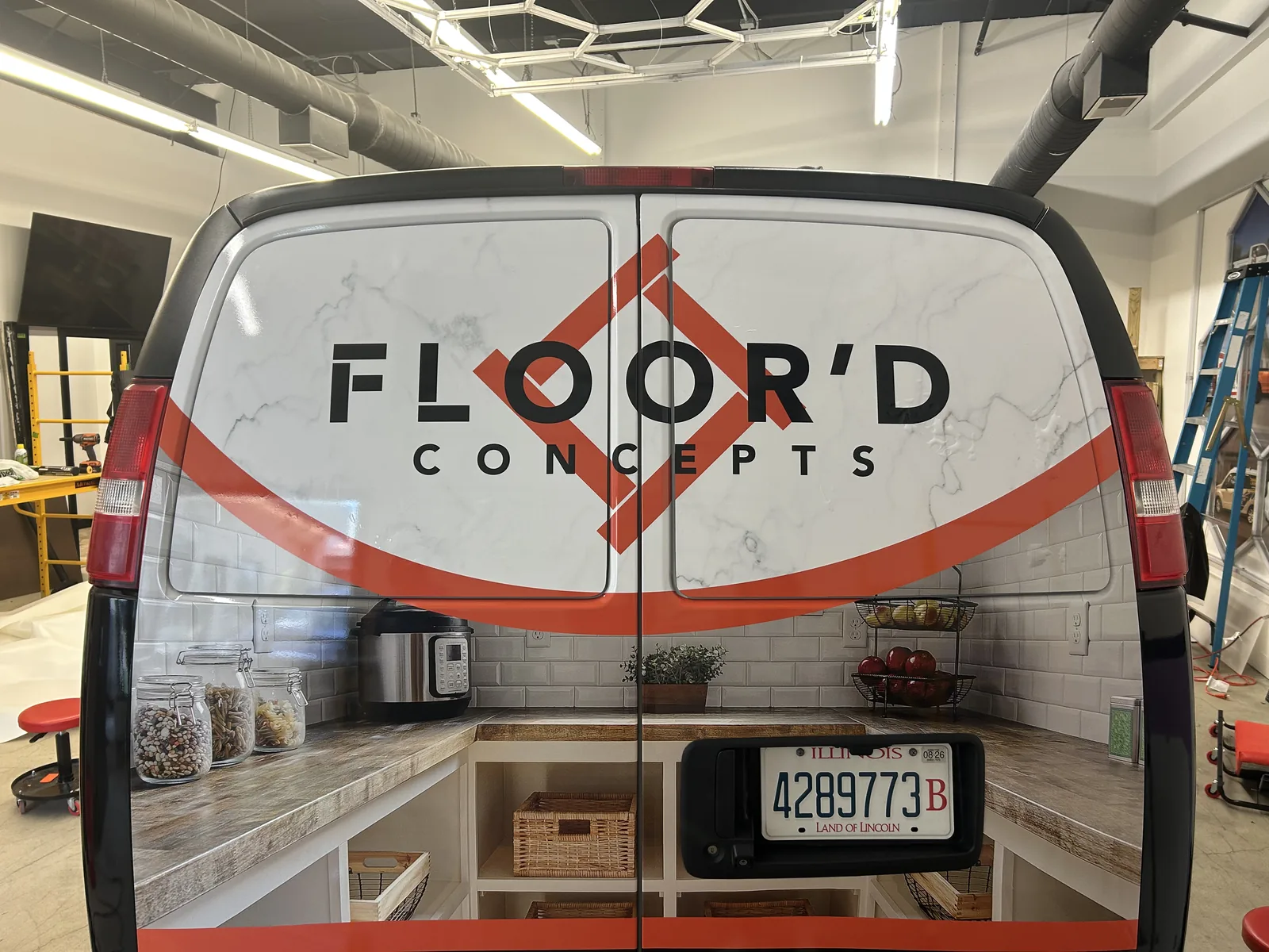 Floor'd Concepts Express van rear doors during install, with perforated film replacing the previous opaque window vinyl.
