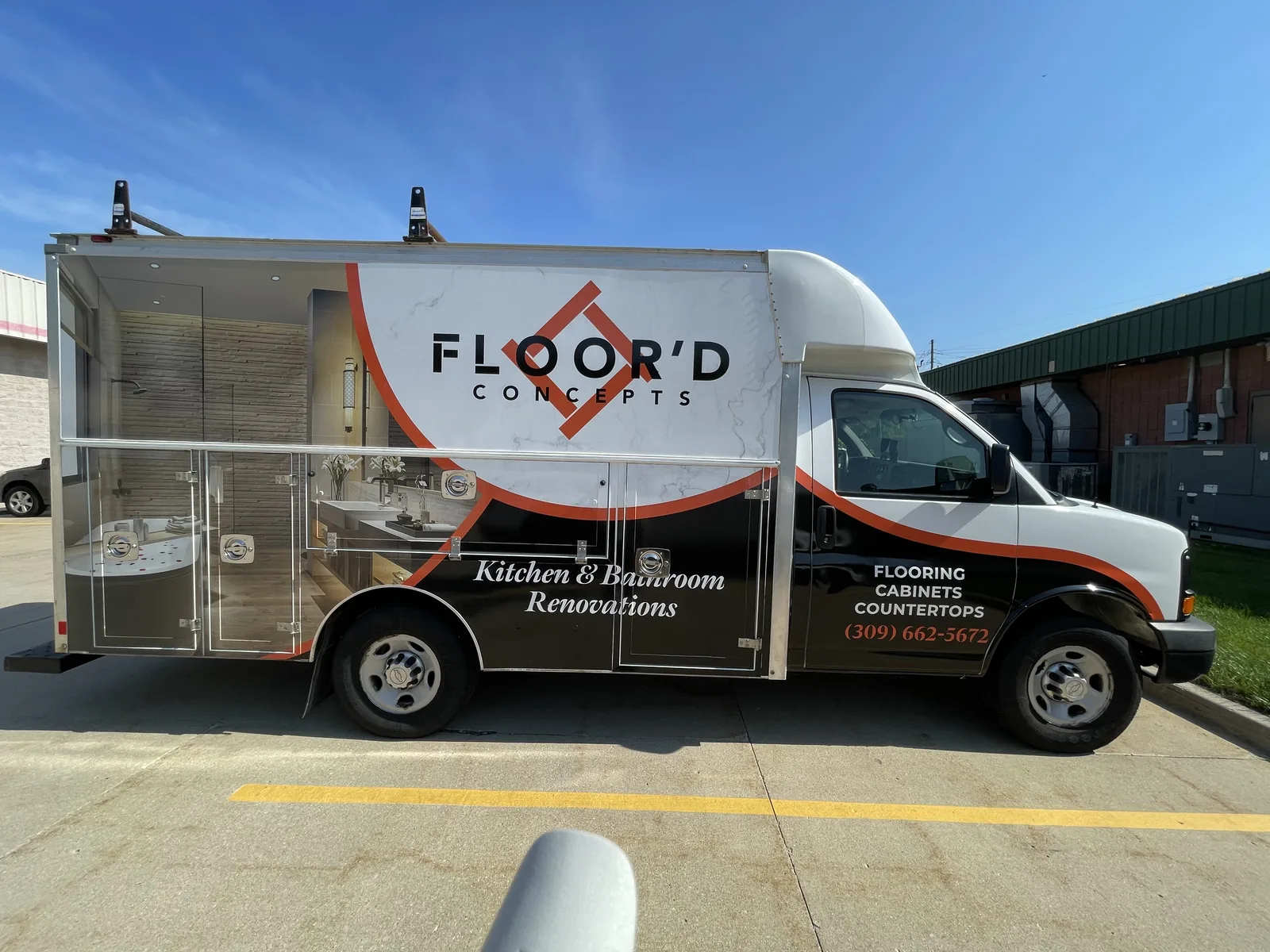 Passenger side of the Floor'd Concepts service van with bathroom photography across the compartment doors.