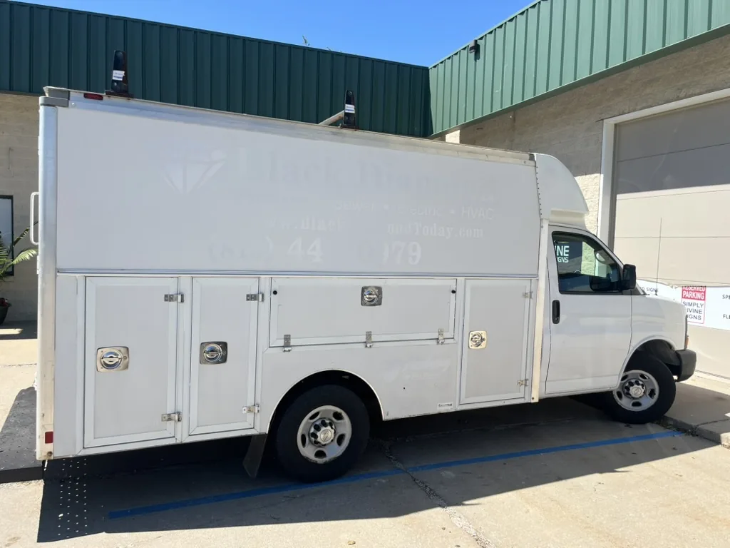 Compartment doors down the side of the service van before the wrap.