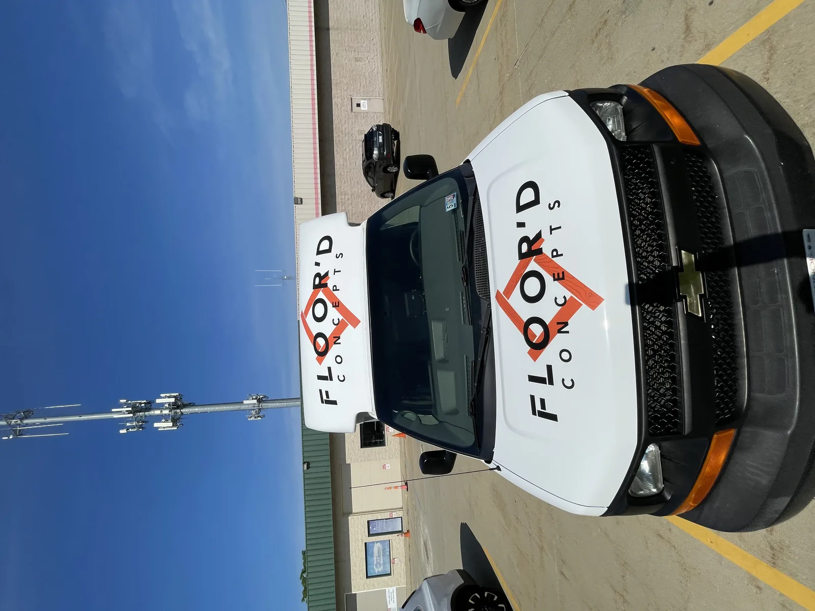 Floor'd Concepts logo applied across the curved front cap and hood of the service van.
