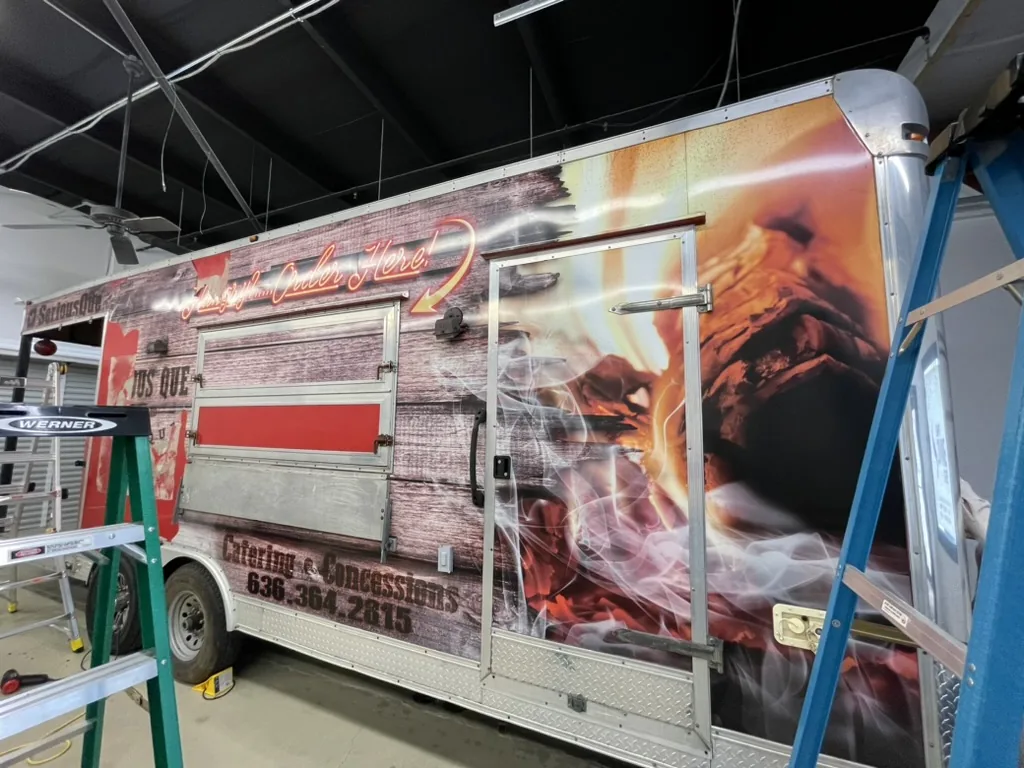 The used food trailer as it arrived, still wrapped for a previous barbecue business.