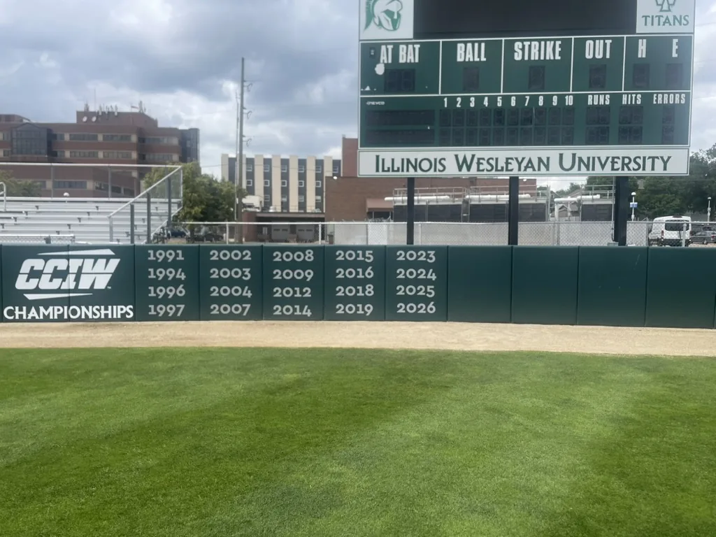 CCIW championship year graphics on the Illinois Wesleyan softball outfield wall, Bloomington, IL.