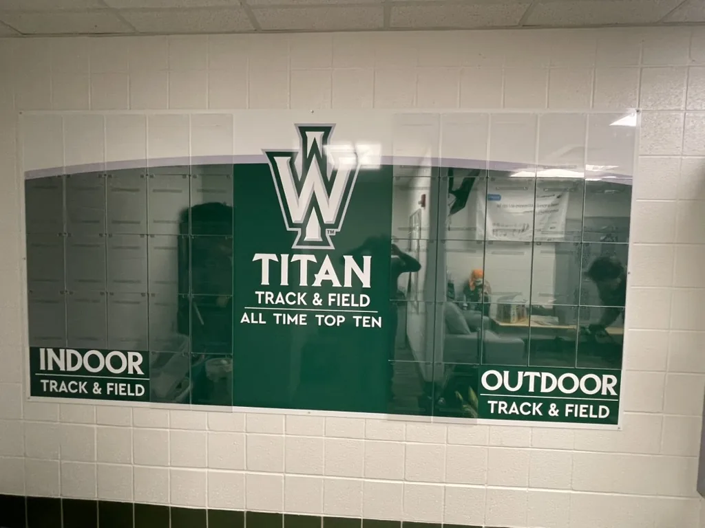 Illinois Wesleyan Titan track and field all-time top ten record board with empty drop-in insert pockets, Bloomington, IL.