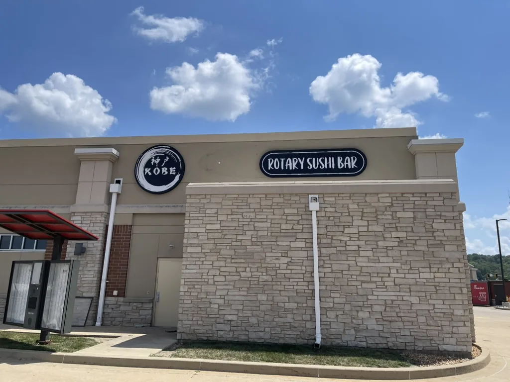 Kobe Rotary Sushi Bar circular logo sign and oval lightbox on the building exterior in East Peoria, IL.