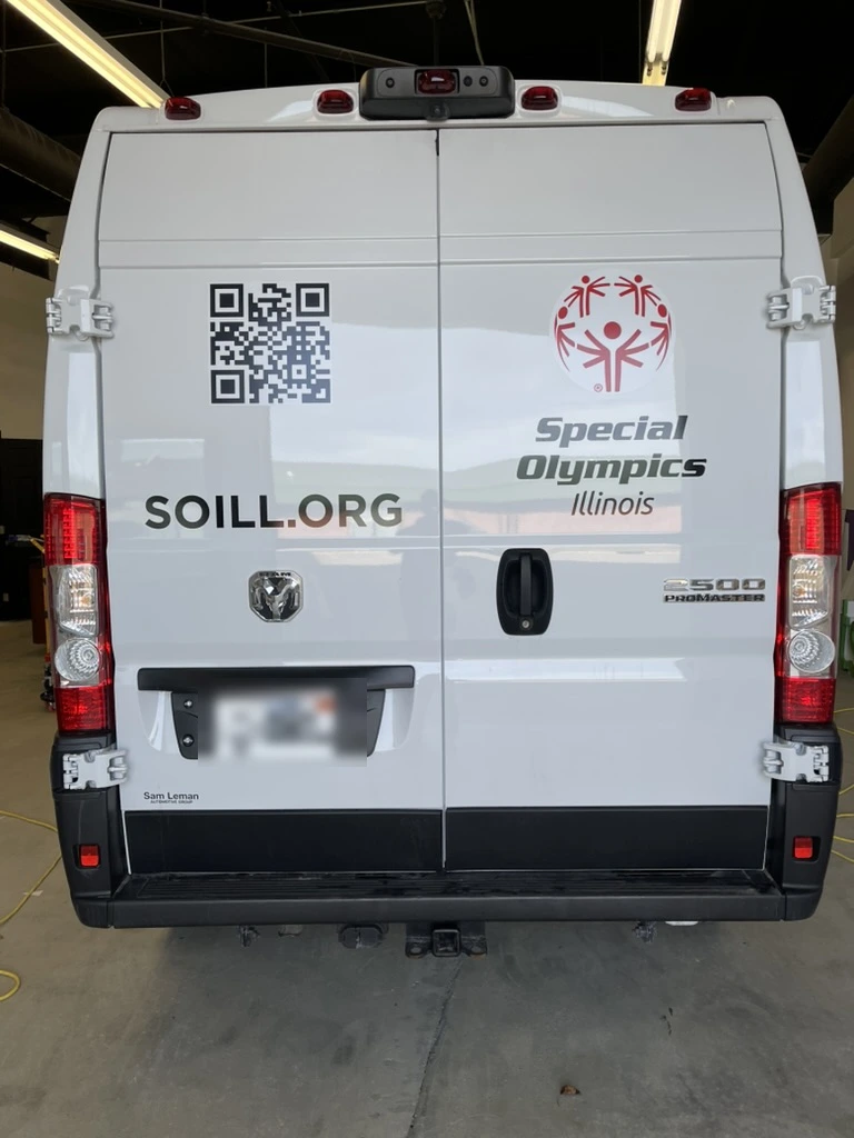 Rear doors of the Special Olympics Illinois Ram ProMaster van, showing the logo and lettering applied in cut vinyl.