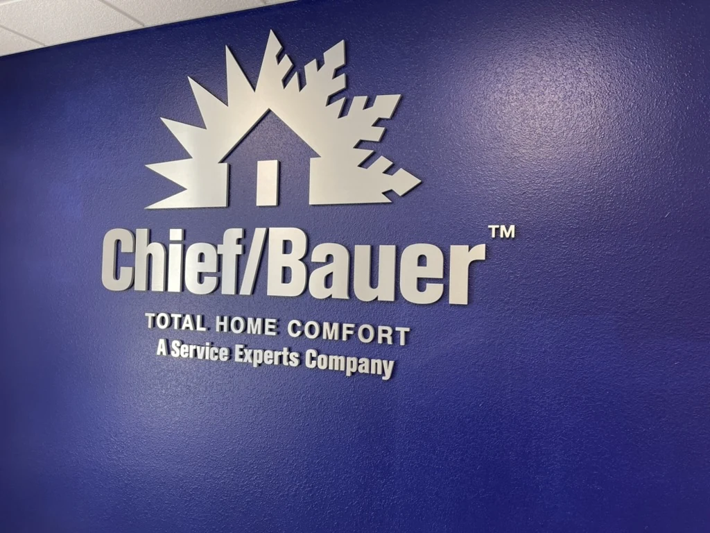 The same wall seen from one side, so the edges of the dimensional letters stand out from the blue wall and each one casts a shadow.