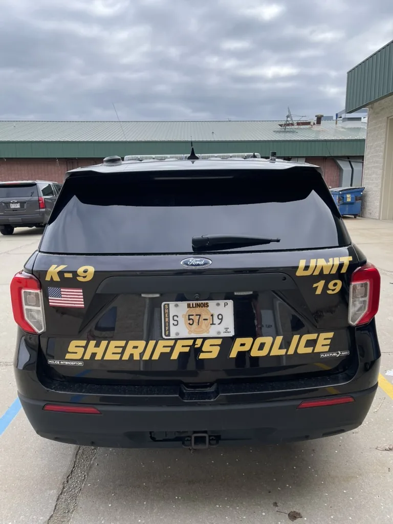 The back of unit 19, with K-9 on one side of the tailgate, UNIT 19 on the other, and SHERIFF'S POLICE in gold above the plate.