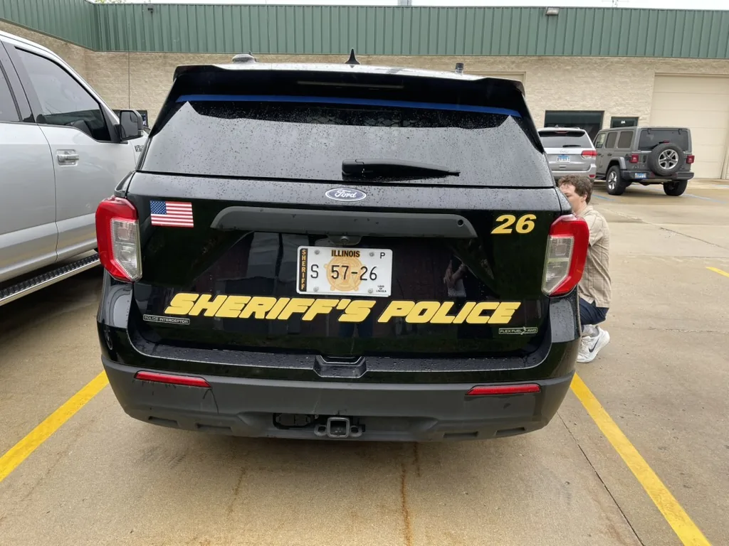The back of unit 26, wet from rain, with the unit number in gold and SHERIFF'S POLICE across the tailgate. This one carries no K-9 markings.