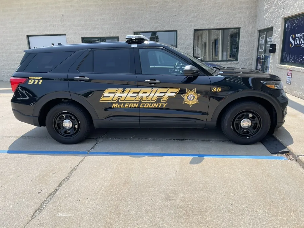 Unit 35, driver side, with gold SHERIFF and McLEAN COUNTY lettering, the county star, the unit number on the front fender, and EMERGENCY 911 at the rear.