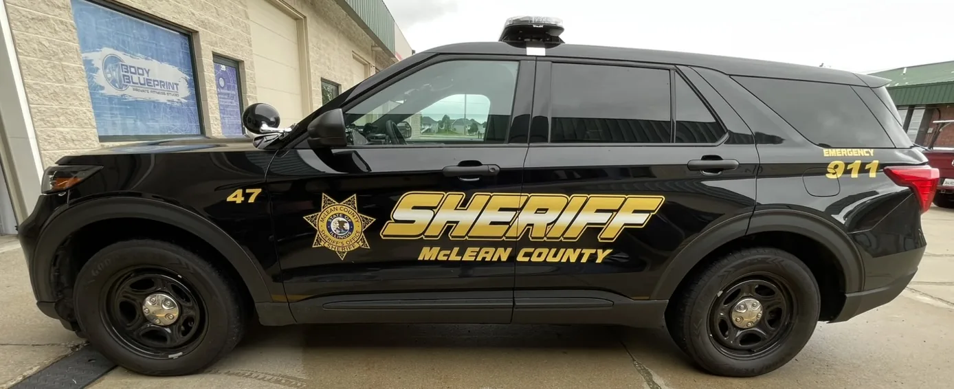 Unit 47, passenger side, in a wide frame. The unit number sits on the front fender ahead of the county star, with SHERIFF and McLEAN COUNTY along the doors and EMERGENCY 911 at the rear.
